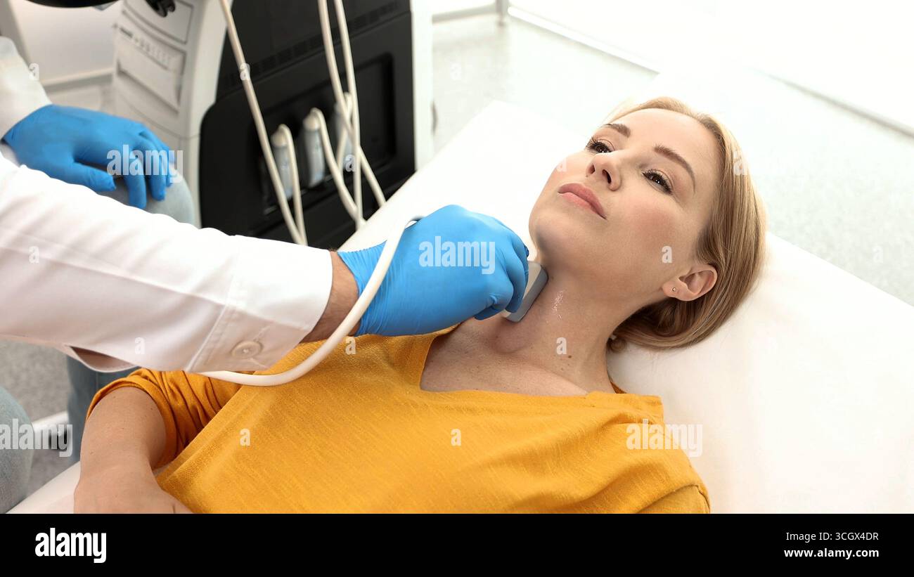 Una donna paziente riceve la diagnosi della tiroide. Trattamento della tireotossicosi e dell'ipotiroidismo. Diagnostica ecografica del sistema endocrino e della tiroide Foto Stock
