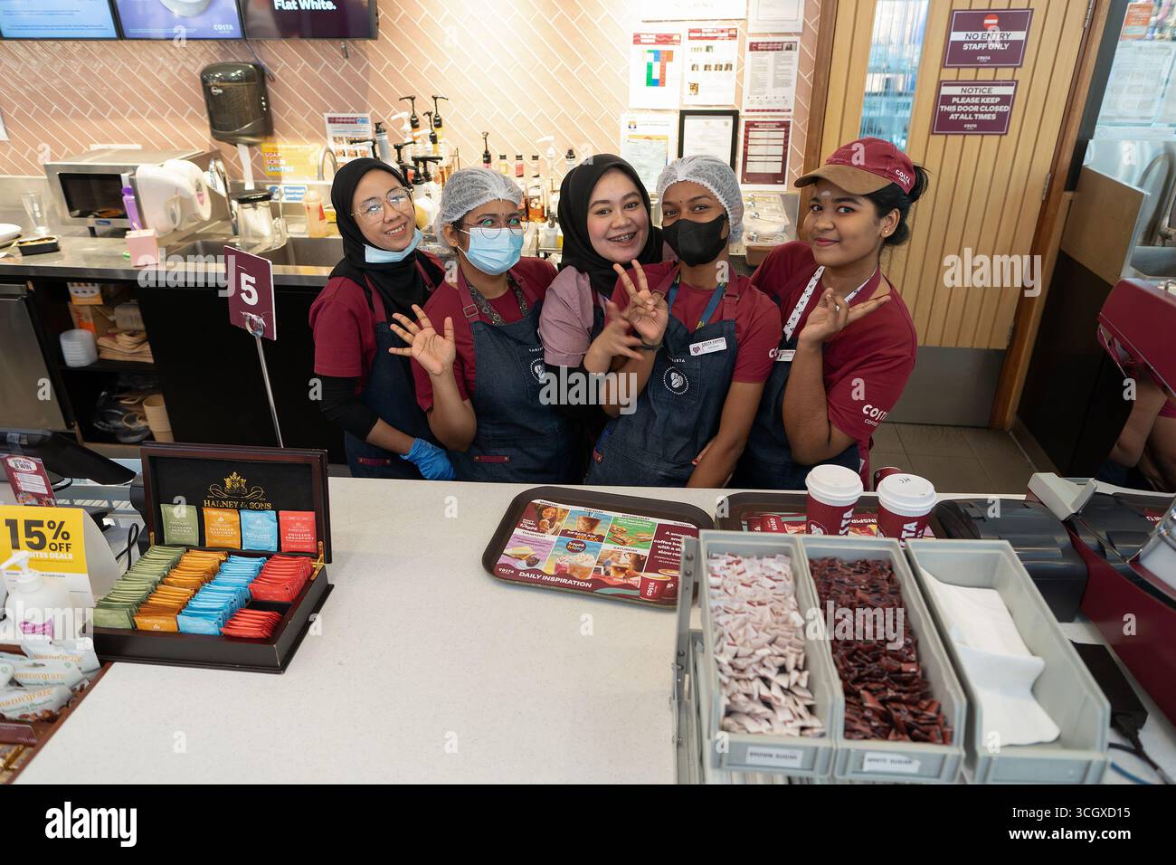 Sepang, Malesia - 29 luglio 2024: Un gruppo di simpatici dipendenti Costa Coffee in posa dietro il banco di servizio presso il loro posto di lavoro a Kuala Lumpur Inte Foto Stock