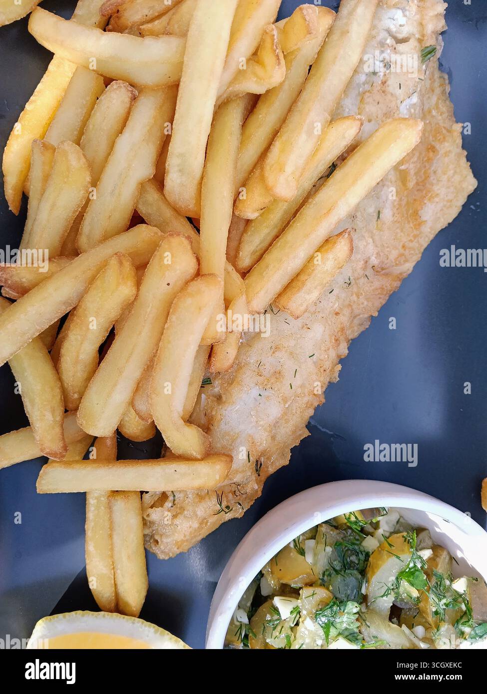 Gusta il delizioso pesce fritto con patatine fritte dorate, un pasto perfetto Foto Stock