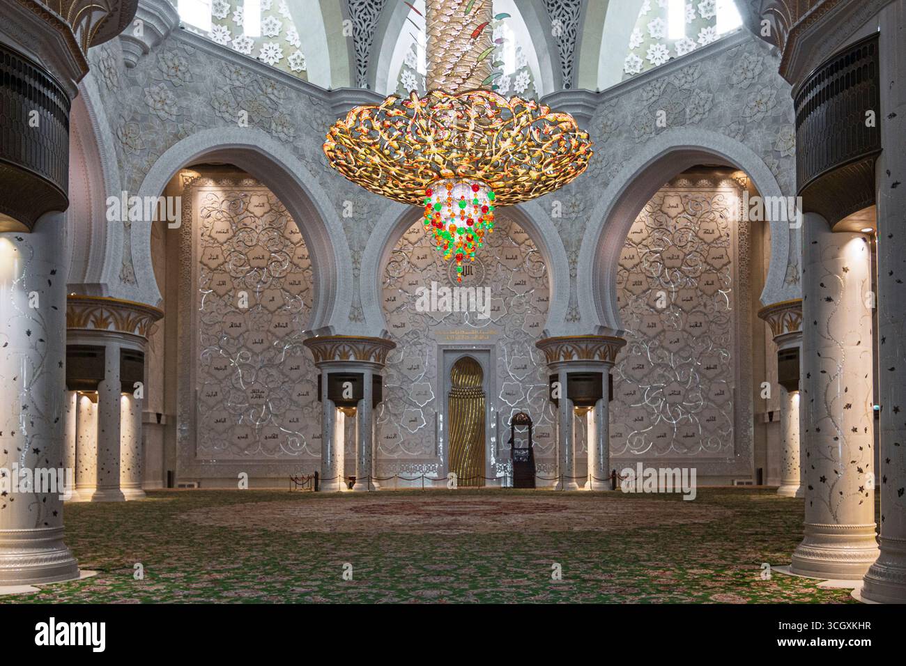Emirati Arabi Uniti - Abu Dhabi - lampadari della sala principale delle preghiere - cascate di cristallo ispirate alle palme che si illuminano sopra tappeti floreali e archi scolpiti Foto Stock