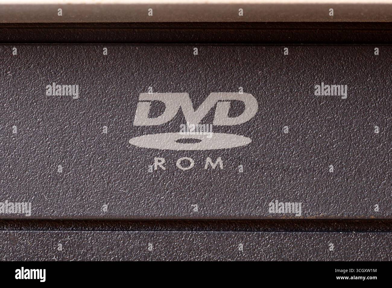 Primo piano macro di un simbolo del logo DVD ROM su un PC unità CD pannello anteriore supporto ottico logo concetto hardware di lettura dati, vecchi formati multimediali, ob meno recente Foto Stock