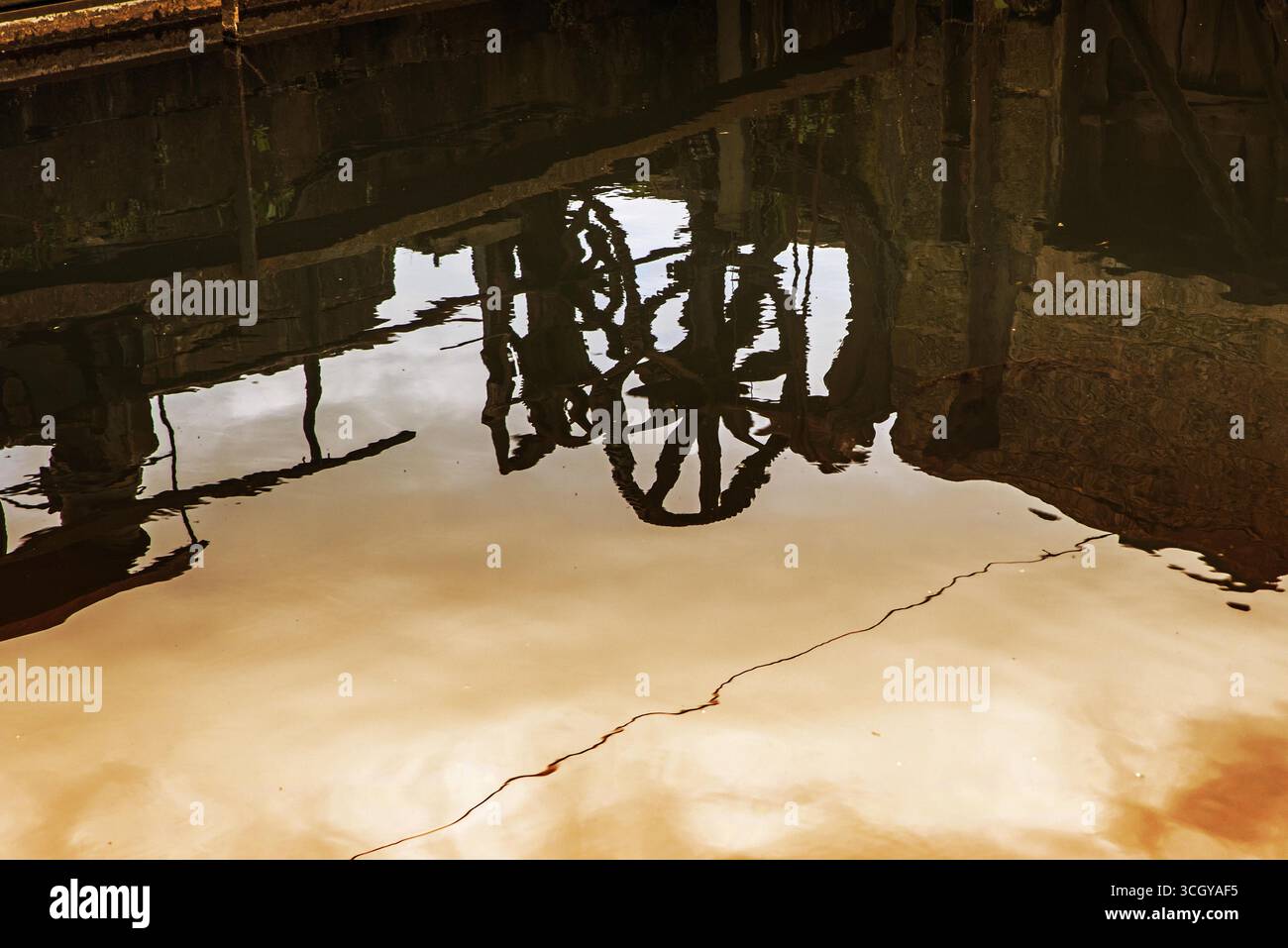 Attrezzatura di avvolgimento della porta di luice riflessa nel fiume Derwent a Belper, Derbyshire, Inghilterra Foto Stock