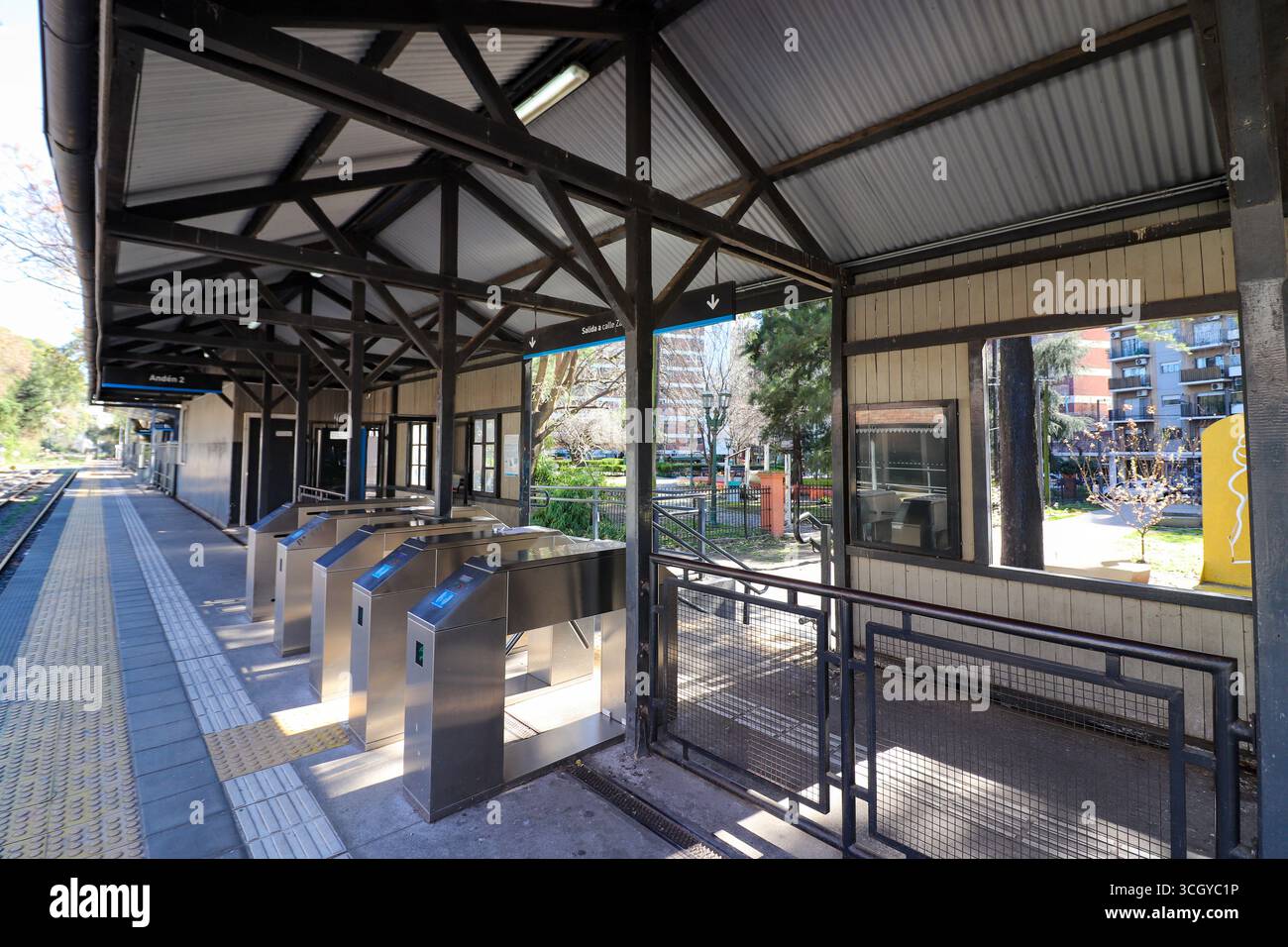 Moderni tornelli in acciaio inox alla stazione ferroviaria Belgrano R. La struttura della piattaforma, con il suo tetto in metallo ondulato e le travi metalliche, mostra il Mitre Foto Stock