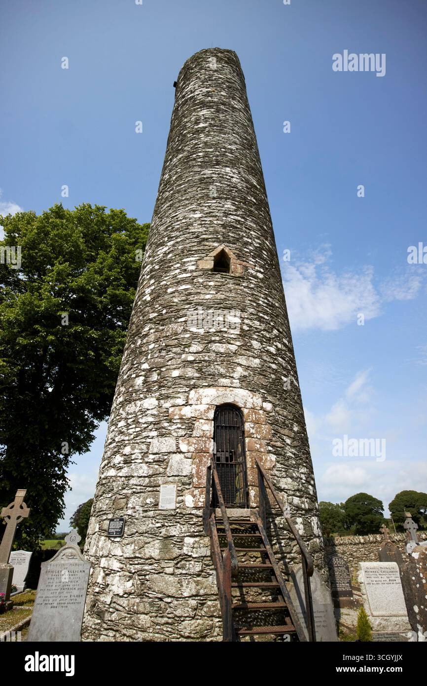 torre rotonda con accesso al cancello d'ingresso al di fuori del terreno rovine di monasterboice insediamento monastico paleocristiano contea di louth repubblica d'irlanda Foto Stock