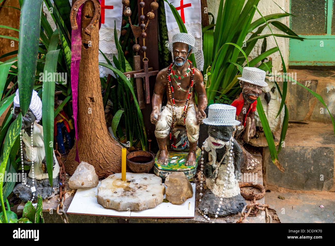 Umbanda e Cristianesimo si mescolano su un altare tra piante con divinità e oggetti religiosi Foto Stock