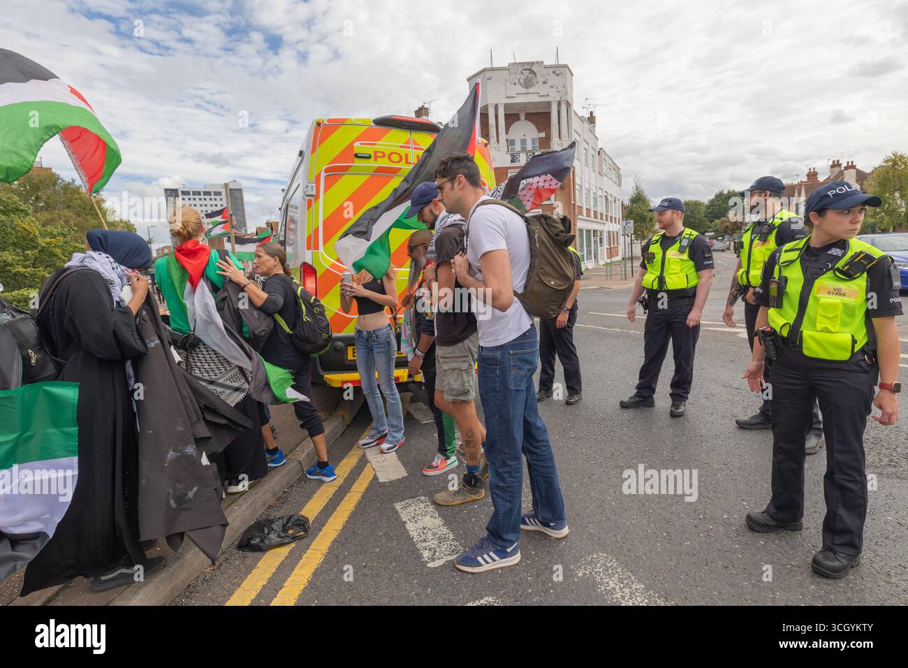 Southend on Sea, Regno Unito. 30 agosto 2025. Un gruppo di manifestanti partecipa alla protesta pro-palestinese in una strada di Southend-on-Sea, sventolando bandiere palestinesi e indossando colori simbolici. Gli agenti di polizia con giubbotti ad alta visibilità monitorano l'evento, con un furgone della polizia di stanza nelle vicinanze. marcia dimostrativa e protesta contro la guerra in corso in Palestina e Gazza. Le zone di esclusione sono state istituite dalla polizia dell'Essex con restrizioni che prevedono un percorso specifico che la dimostrazione deve seguire. Penelope Barritt/Alamy Live News Foto Stock