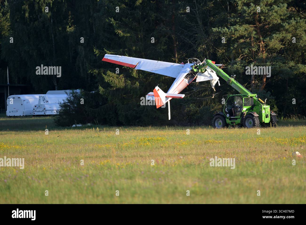 Reinsdorf, Germania. 30 agosto 2025. Un piccolo aereo distrutto viene trasportato lungo la pista dell'aeroporto vicino a Reinsdorf. Secondo la polizia, due persone sono morte quando l'aliante si è schiantato. Credito: Michael Bahlo/dpa - ATTENZIONE: L'identificazione degli aeromobili è stata pixellata per motivi legali/dpa/Alamy Live News Foto Stock