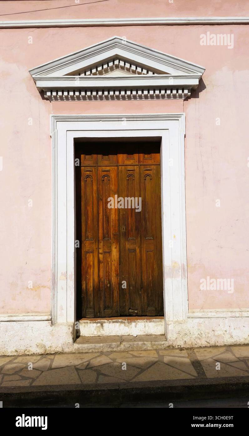 Vecchie porte d'ingresso in legno nostalgiche con autentico fascino messicano, decorate con archi colorati e colonne ornate Foto Stock