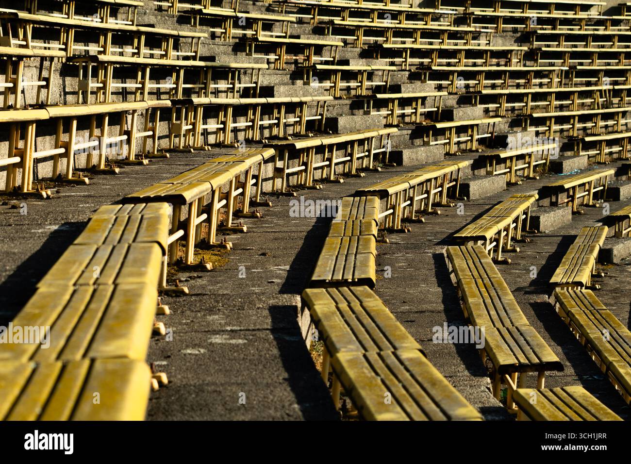 File di posti gialli allo stadio sportivo Strahov abbandonato e in rovina a Praga. Foto Stock