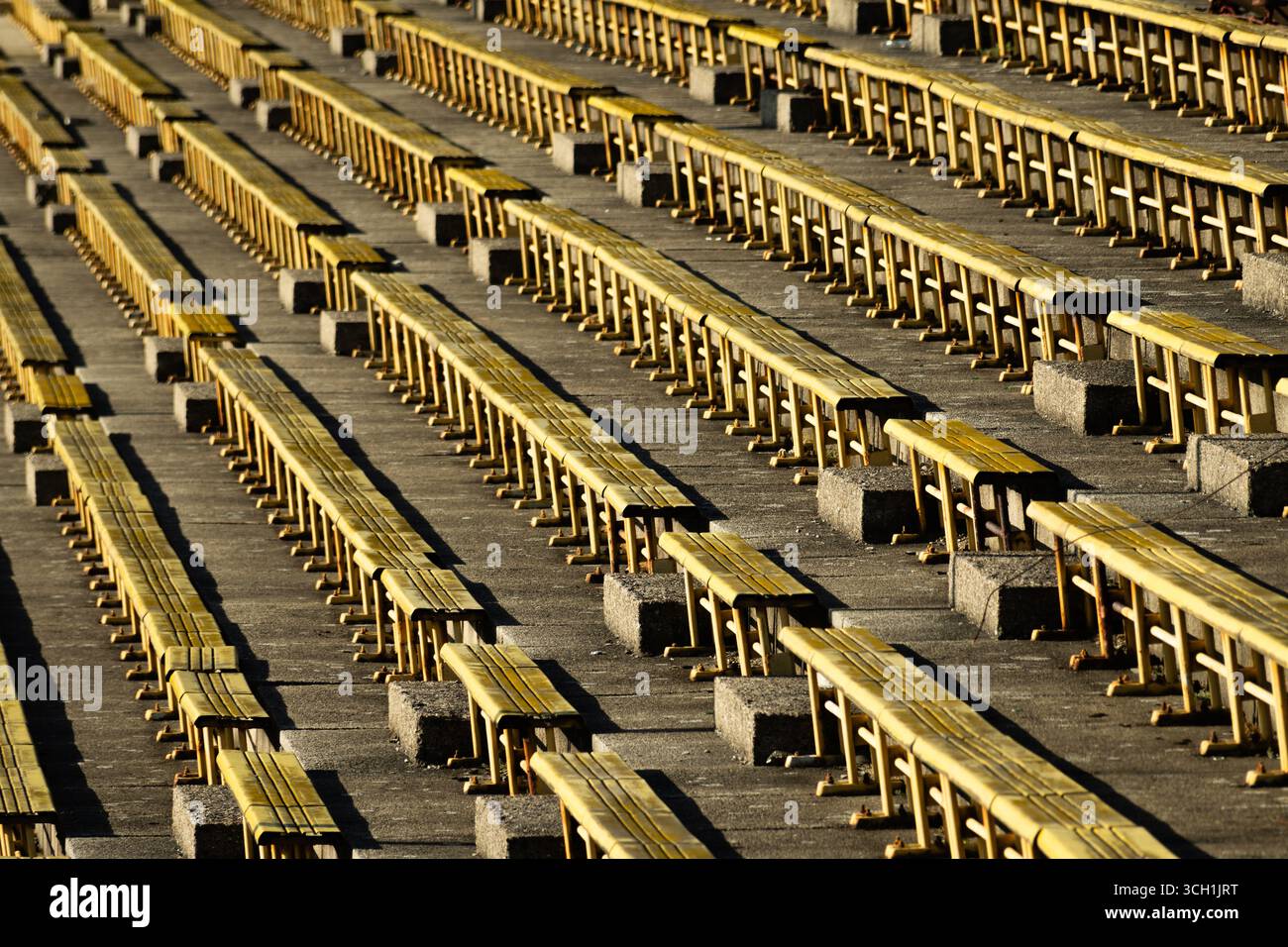 File di posti gialli allo stadio sportivo Strahov abbandonato e in rovina a Praga. Foto Stock