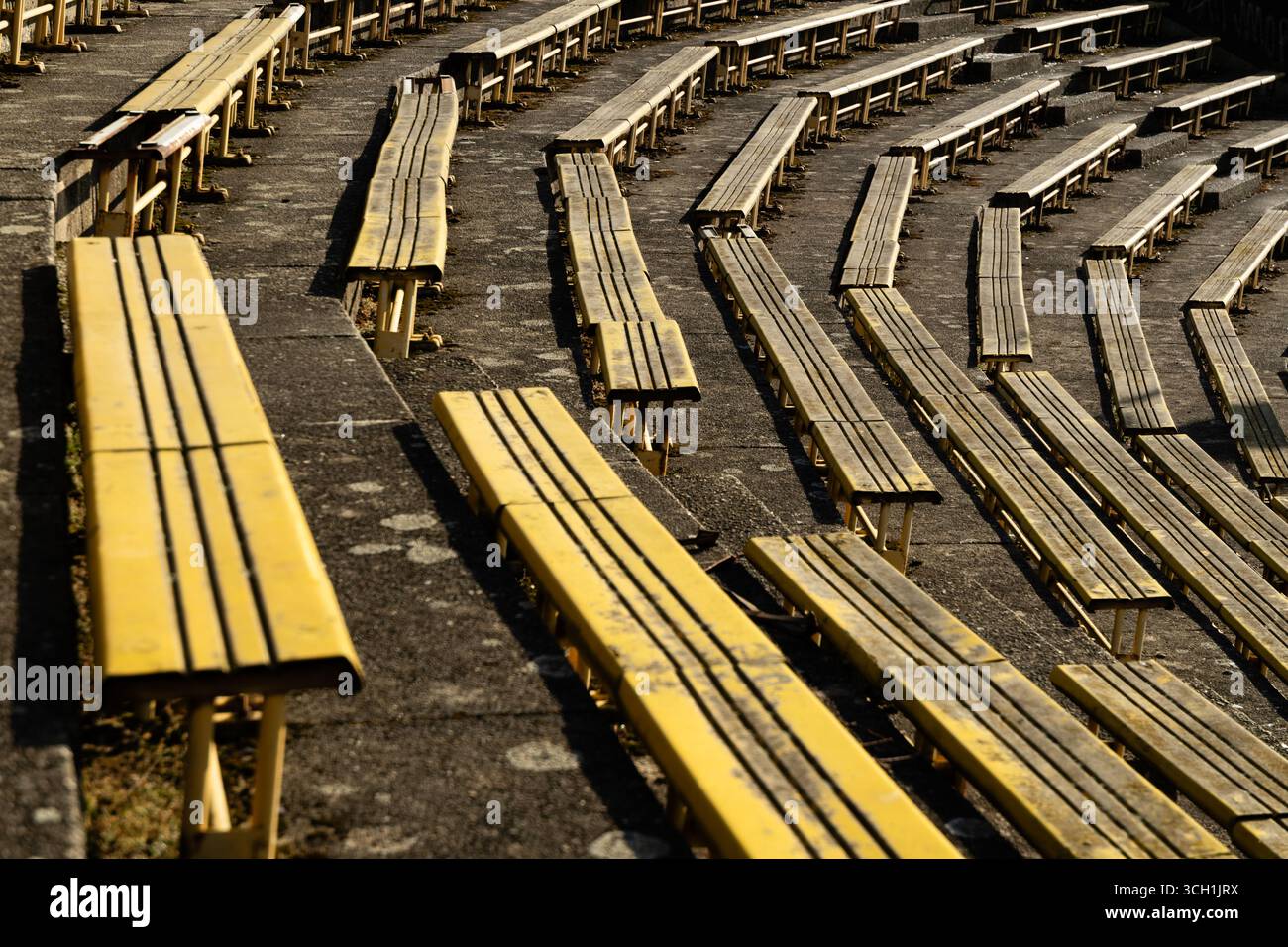File di posti gialli allo stadio sportivo Strahov abbandonato e in rovina a Praga. Foto Stock