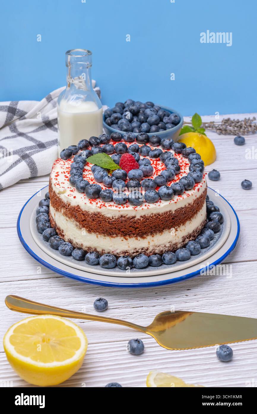Torta di velluto rosso con essenza di rosa: Acqua di rosa nella pasticceria e mirtilli rossi freschi come contorno Foto Stock