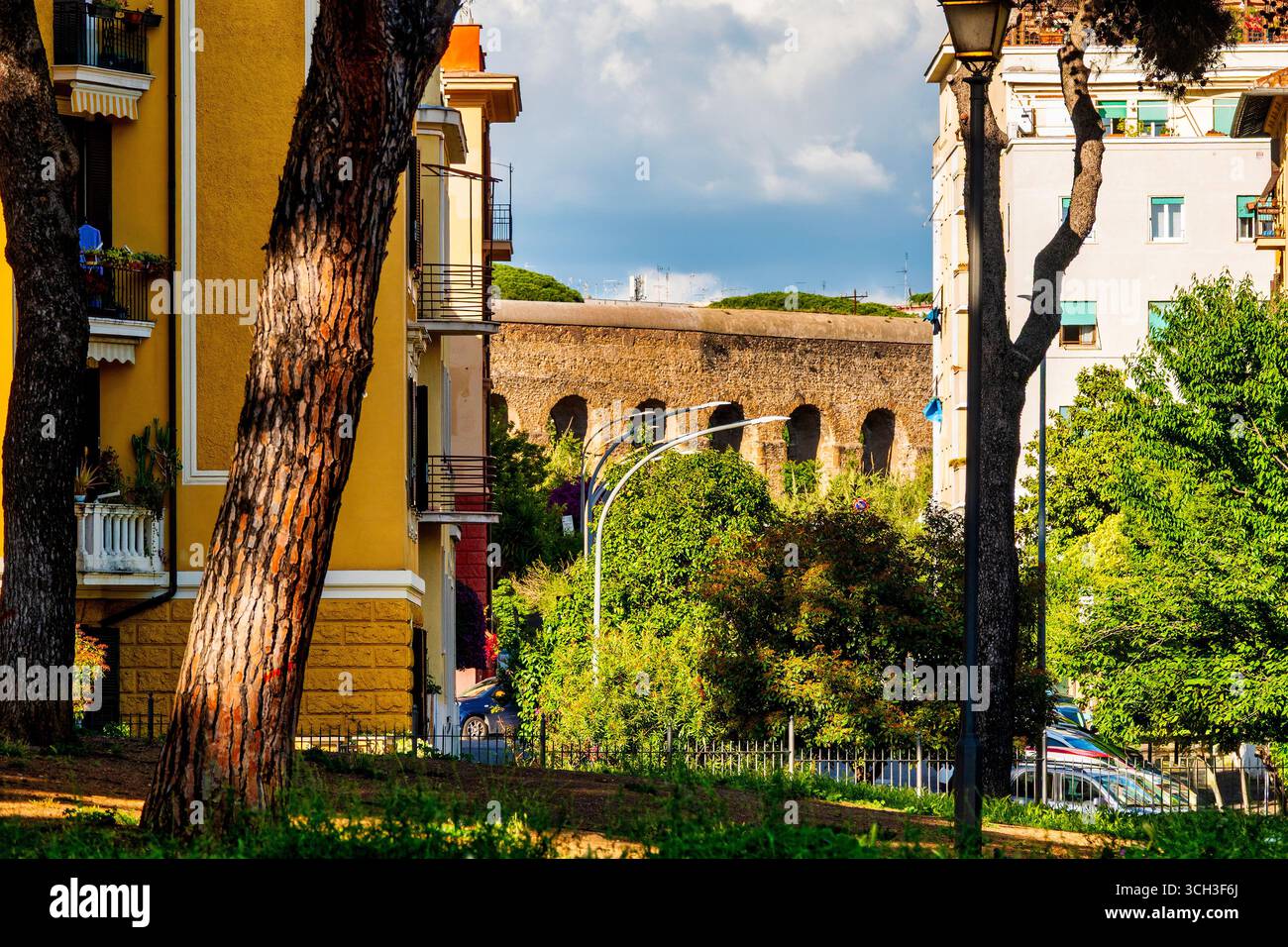 Vista dell'Acquedotto felice incorniciato da alberi ed edifici nel parco di Villa Fiorelli, Roma, Italia. Foto Stock