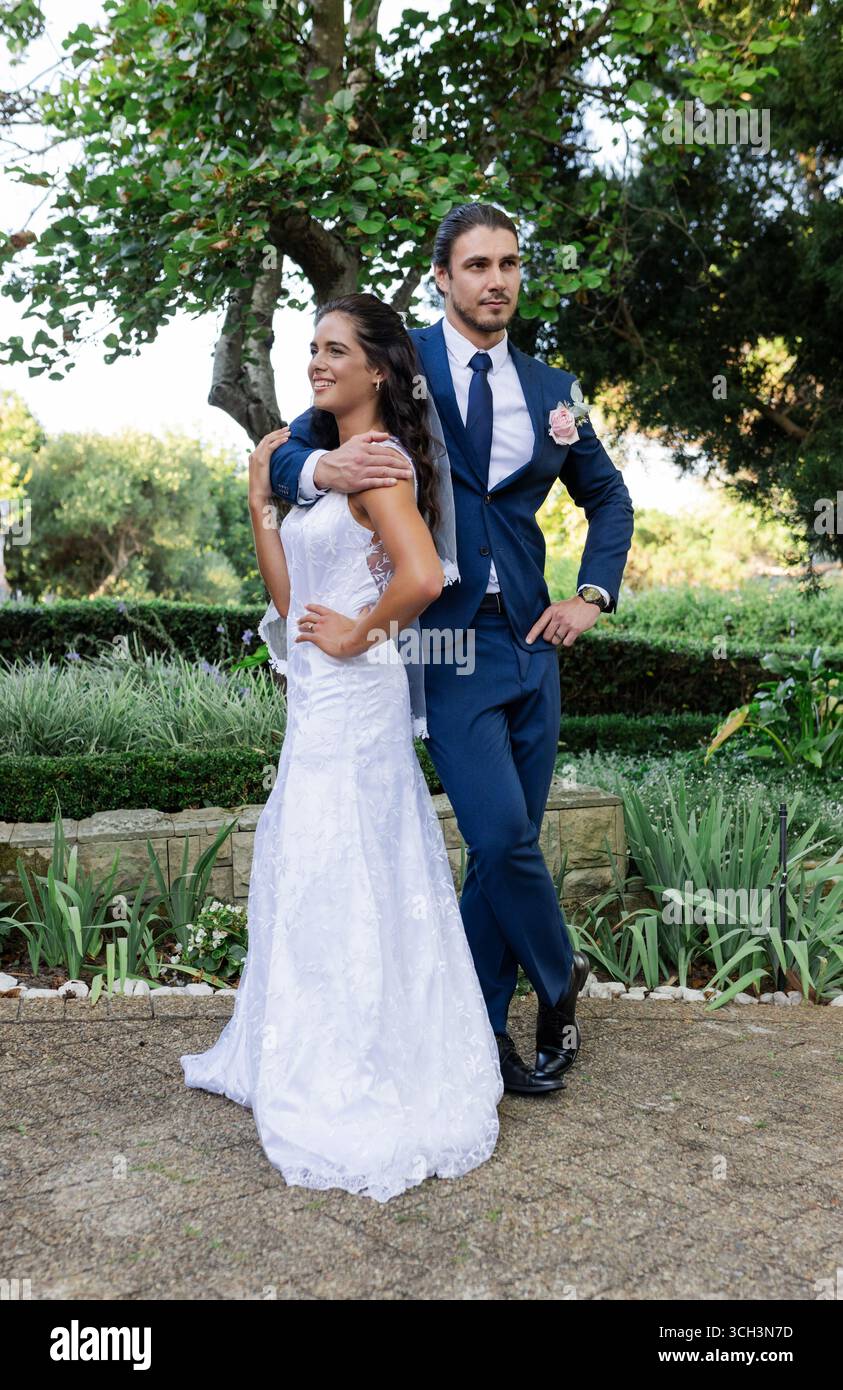 Sposa e sposo in posa in giardino per celebrare il giorno del loro matrimonio Foto Stock