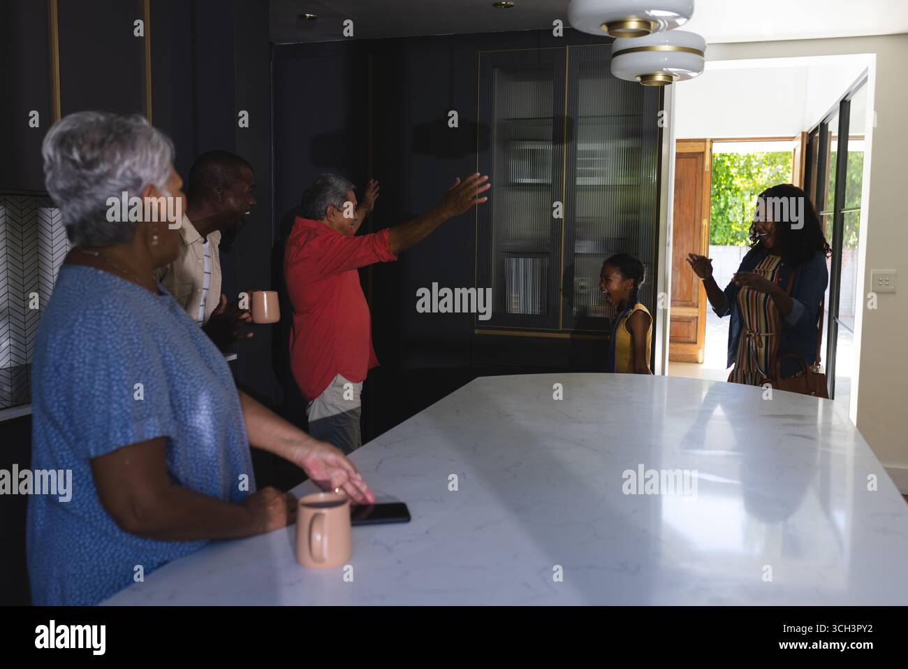 In cucina, i nonni accolgono la figlia e il bambino con sorrisi e la riunione di famiglia Foto Stock