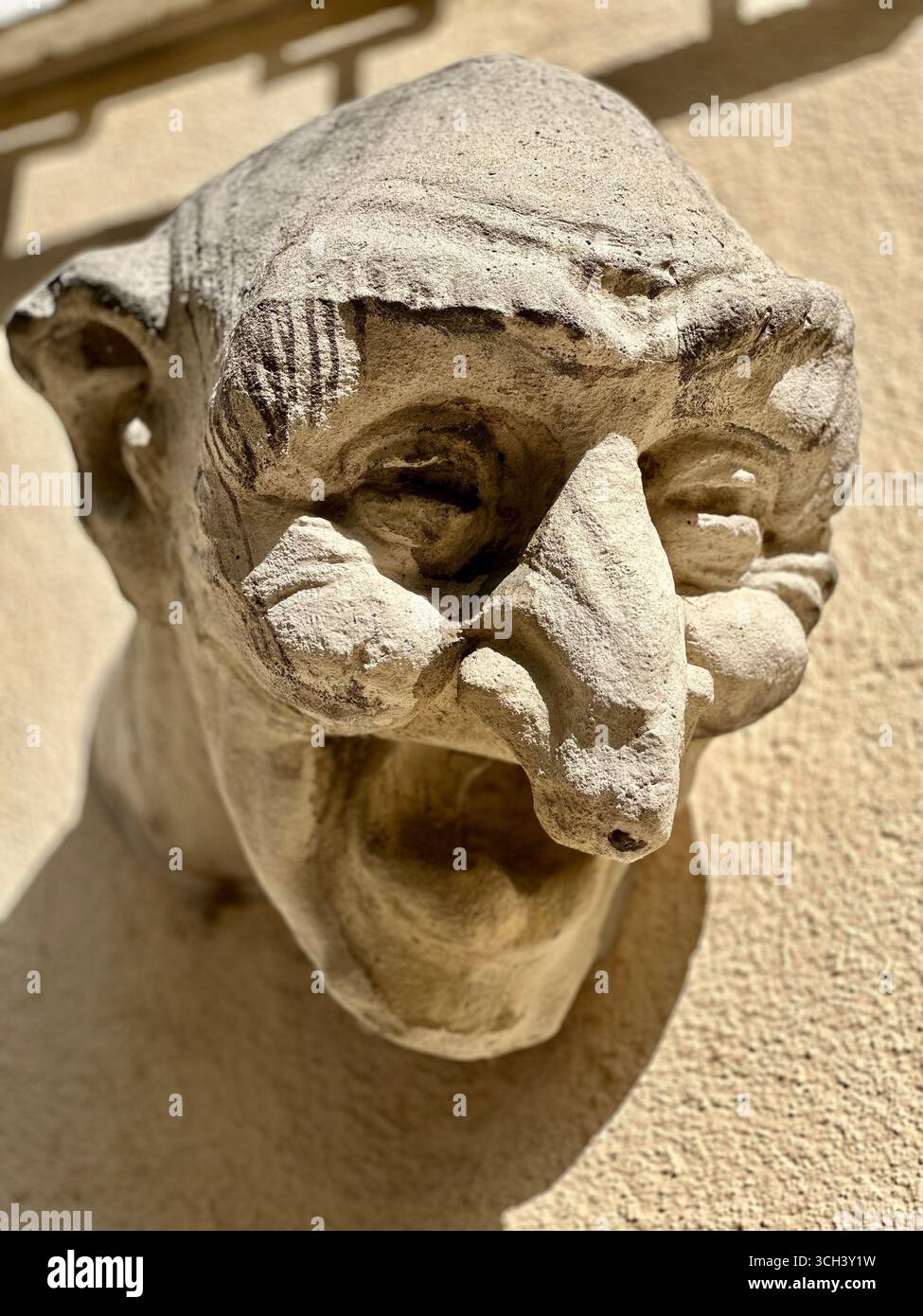 Primo piano di un gargoyle in pietra intemprata su una facciata di un edificio storico in Lussemburgo, che mette in risalto dettagli architettonici e sculture. Foto Stock