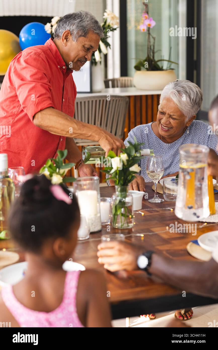 Bere qualcosa per la nonna, il nonno sorridente a diverse riunioni di famiglia, in giardino Foto Stock
