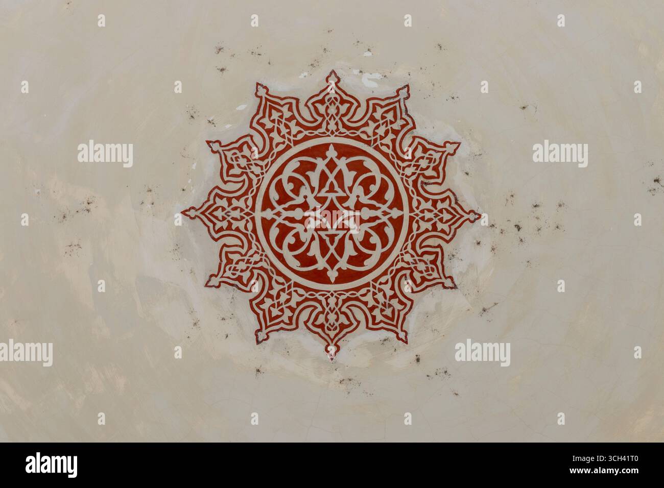 Turchia - Istanbul - Moschea del Sultano Ahmed - medaglione di rosetta cremisi dipinto su soffitto in gesso chiaro, intricati arabeschi Foto Stock