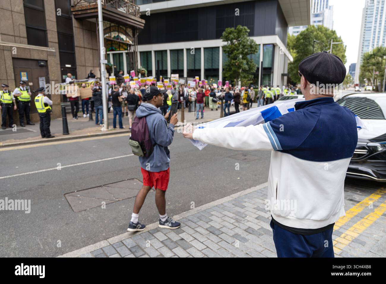 LONDRA, REGNO UNITO. 31 agosto 2025. I manifestanti anti anti-immigrazione di estrema destra gridano e scherzano contro gli attivisti del razzismo durante una manifestazione fuori dall'hotel internazionale a Canary Wharf. La protesta ha sostenuto i richiedenti asilo alloggiati nell'hotel e si è opposta all'ostilità e al razzismo di estrema destra. Crediti: Pete Speller/Alamy Live News Foto Stock