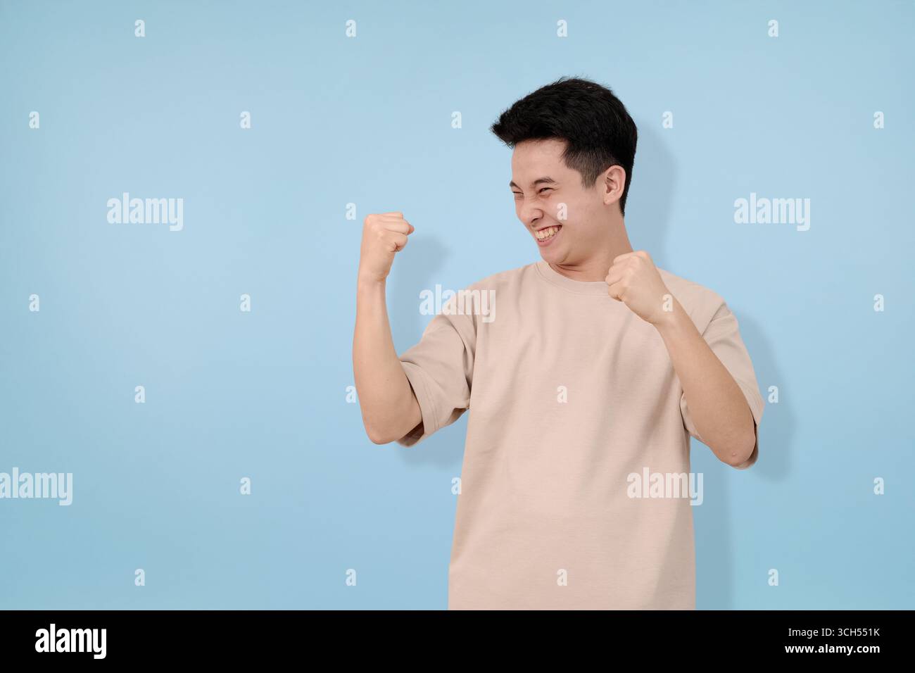 l'espressione dell'uomo eccitata celebra con pugni chiusi in una gioia di euforia Foto Stock