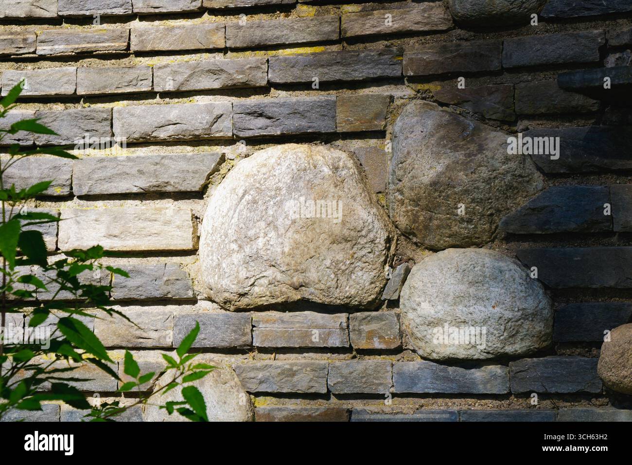 Una vista ravvicinata di una parete in pietra e mattoni illuminata dalla luce del sole. Foto Stock