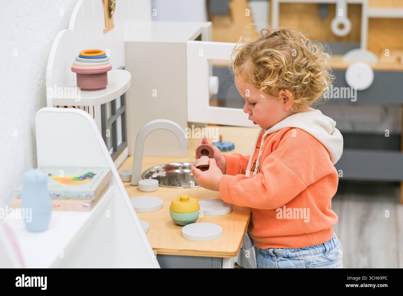 mosca, russia, 23.10.2024 un bambino che gioca con un set di giocattoli da cucina in legno, si impegna in un gioco fantasioso, concetto di educazione della prima infanzia, per prescolare Foto Stock