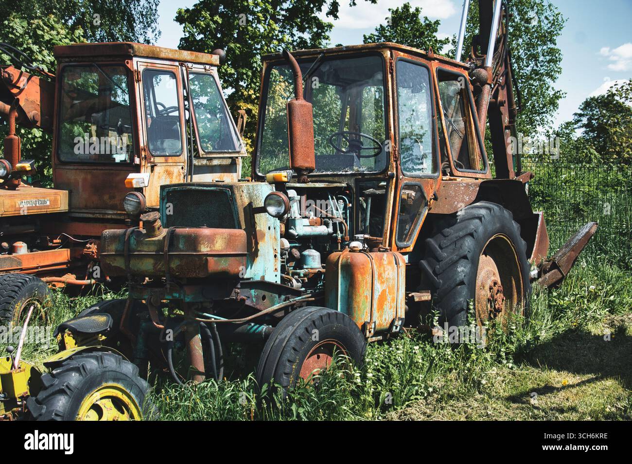 Rusty Blue Tractor in Overgrown Grass with Rural Decay Scene Foto Stock