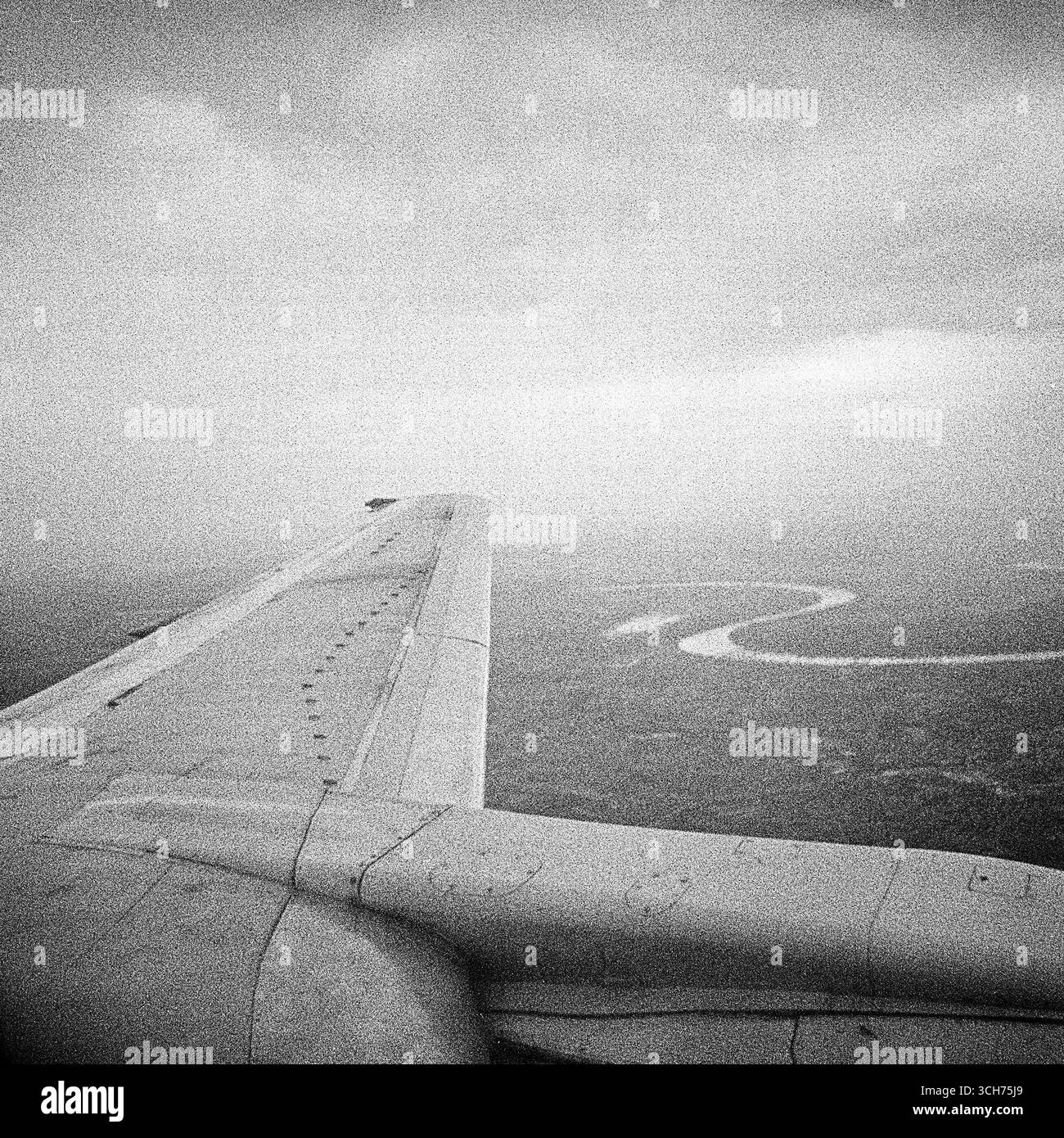 Ala dell'aereo sopra le nuvole: Formato quadrato bianco e nero dal posto vicino al finestrino Foto Stock