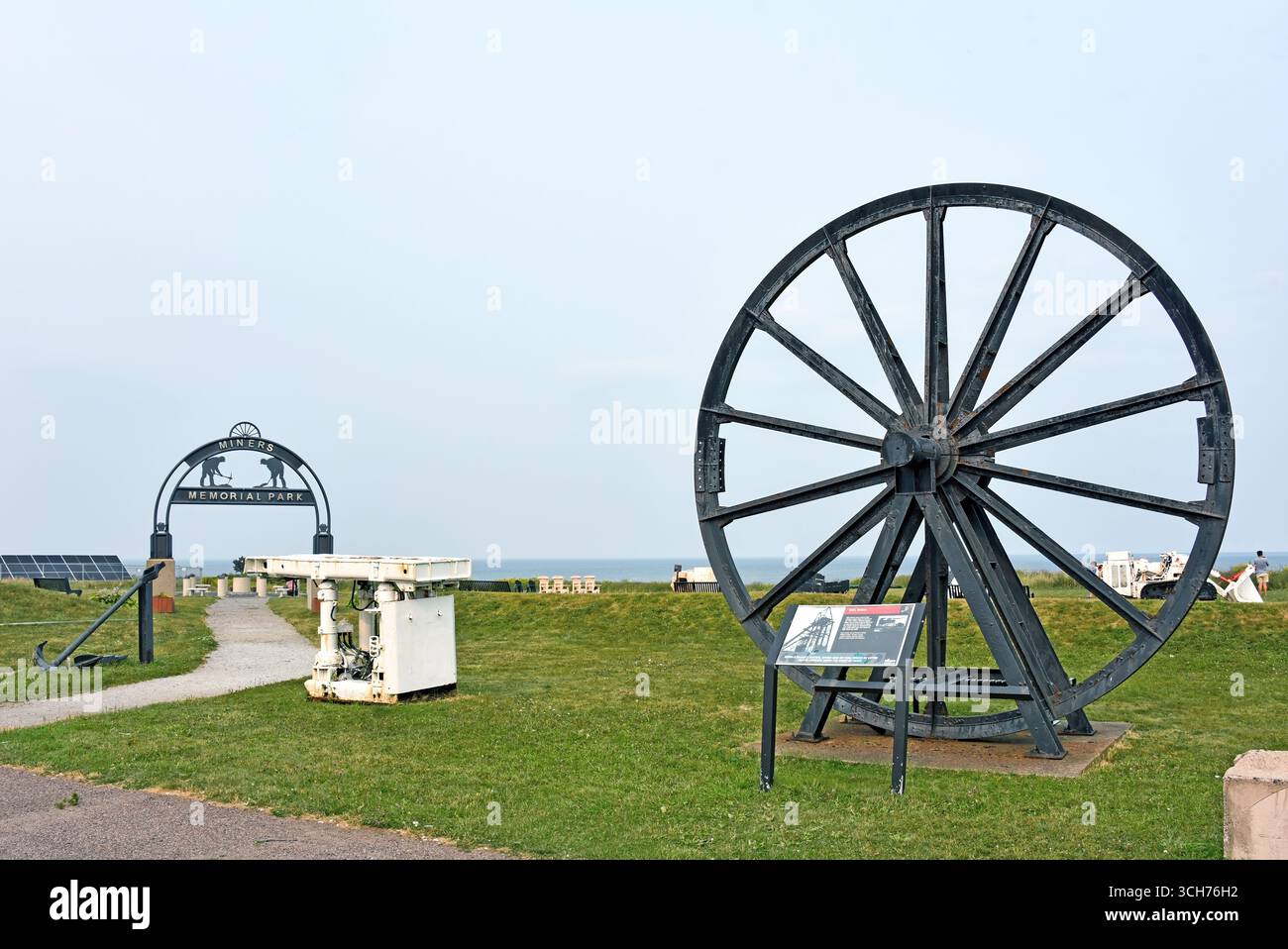 Glace Bay, Canada - 4 agosto 2025: Mostre all'esterno del Cape Breton Miners Museum, nel Miners Memorial Park, tra cui un'enorme ruota di toro utilizzata Foto Stock