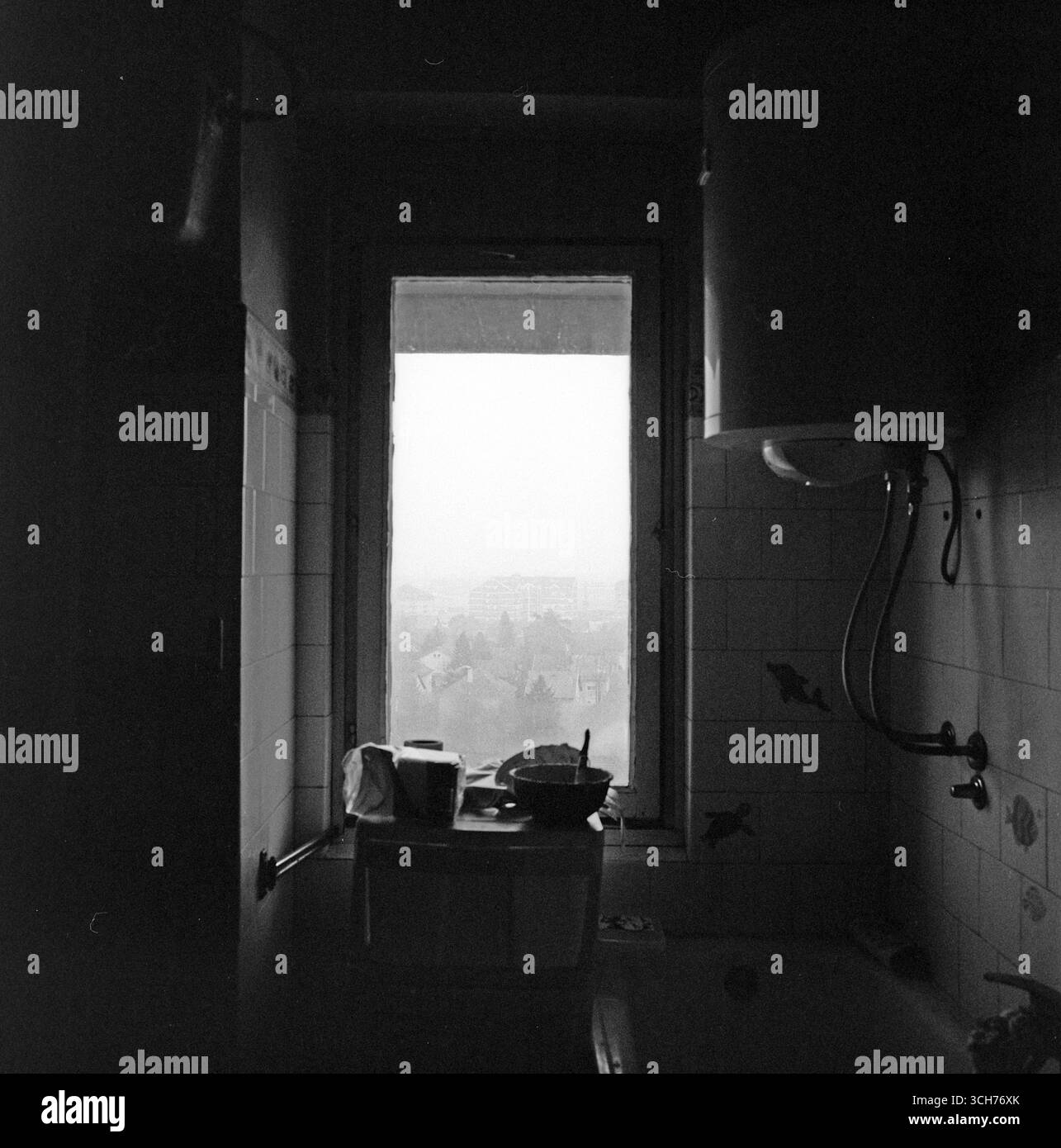 Vista del Sombor invernale attraverso una finestra nebbiosa di un vecchio bagno, catturata in bianco e nero in un film analogico Hasselblad di medio formato. Foto Stock