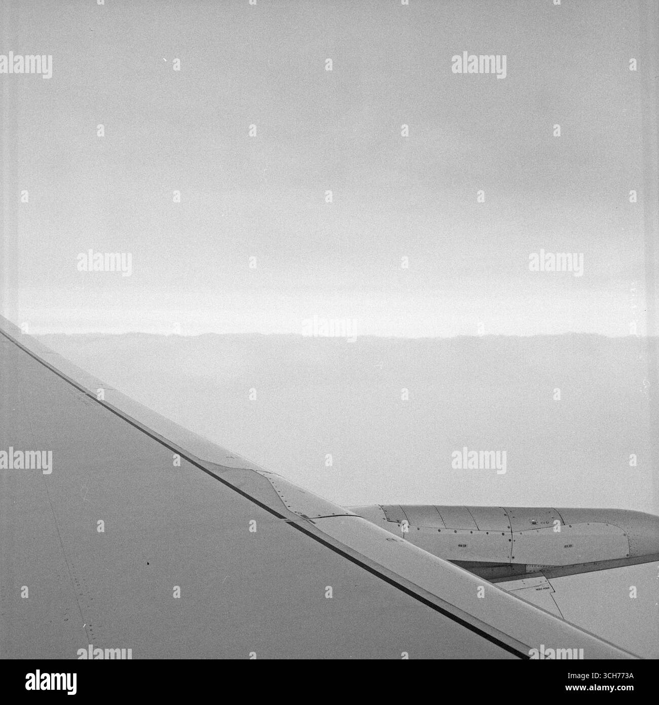 Ala dell'aereo sopra le nuvole: Formato quadrato bianco e nero dal posto vicino al finestrino Foto Stock