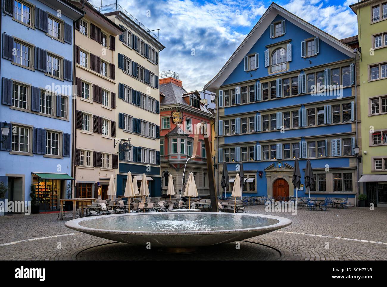 La famosa piazza Munsterhof con edifici storici colorati e una fontana nell'Altstadt o nella città vecchia di Zurigo, in Svizzera Foto Stock