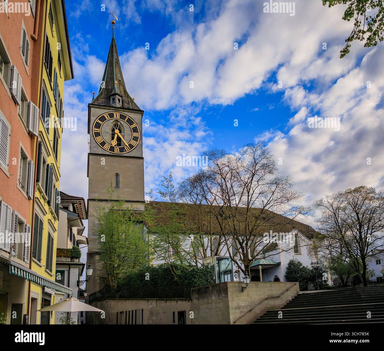 L'iconica chiesa di San Pietro con il più grande orologio della chiesa d'Europa incorniciato da edifici storici nella città vecchia o nell'Altstadt di Zurigo, Svizzera Foto Stock
