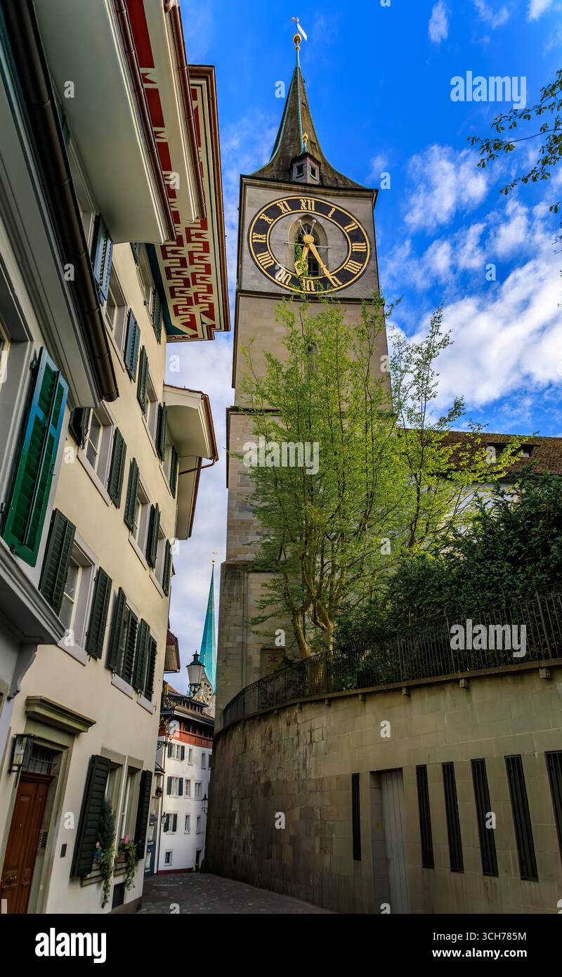 L'iconica chiesa di San Pietro con il più grande orologio della chiesa d'Europa incorniciato da edifici storici nella città vecchia o nell'Altstadt di Zurigo, Svizzera Foto Stock