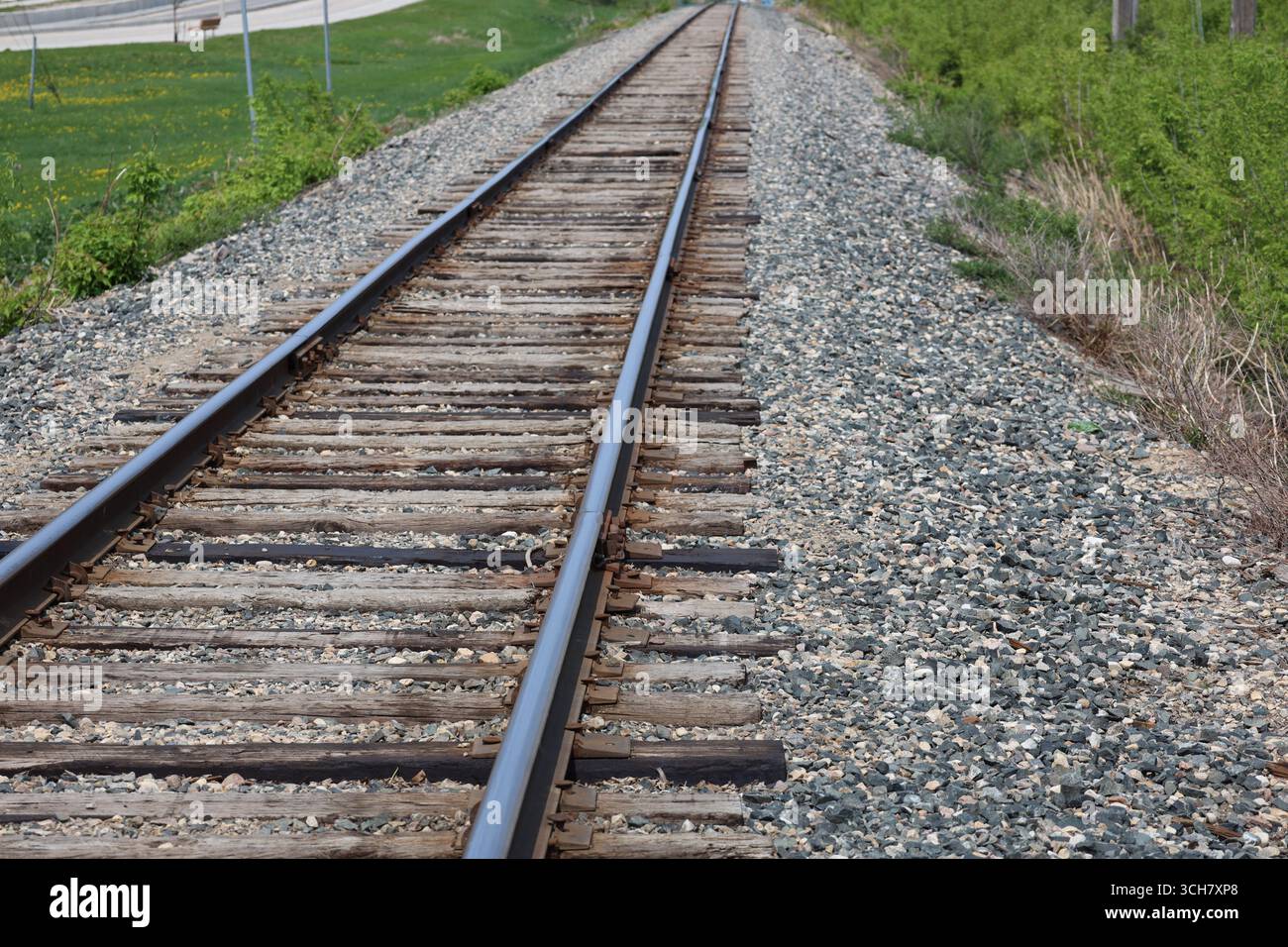 vista ravvicinata lungo una linea ferroviaria con lacci di legno usurati e letto di ghiaia Foto Stock