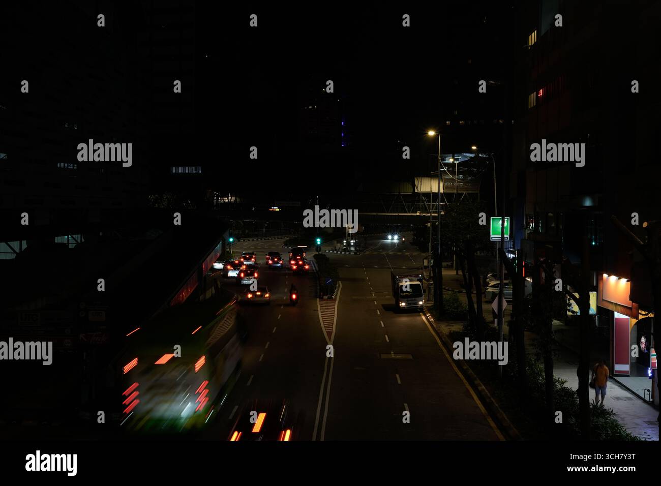 Una strada urbana trafficata di notte mostra il traffico in movimento Foto Stock
