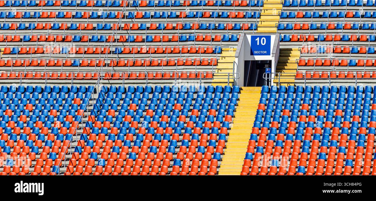 tribuni vuoti dello stadio di calcio. file di posti a sedere multicolore. Foto Stock