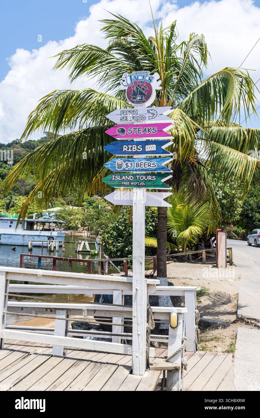 Consolation Bight, Roatan Island, Honduras - 16 aprile 2024: I cartelli con frecce di legno si trovano a Consolation Bight, vicino al porto di Roatan in Hondur Foto Stock