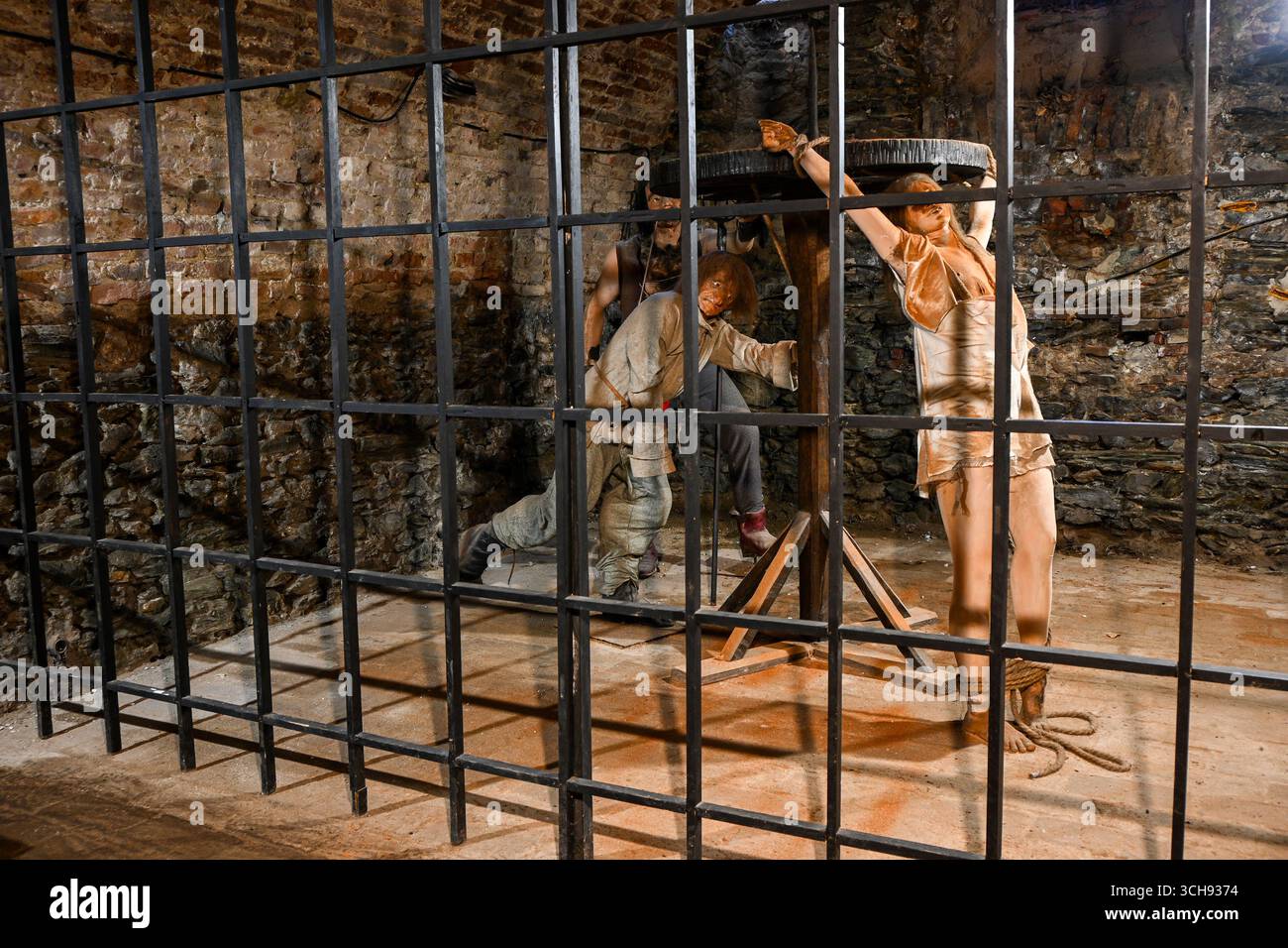 Carnefici torturano una vittima in una prigione medievale, mostrando metodi di punizione storici. Foto Stock