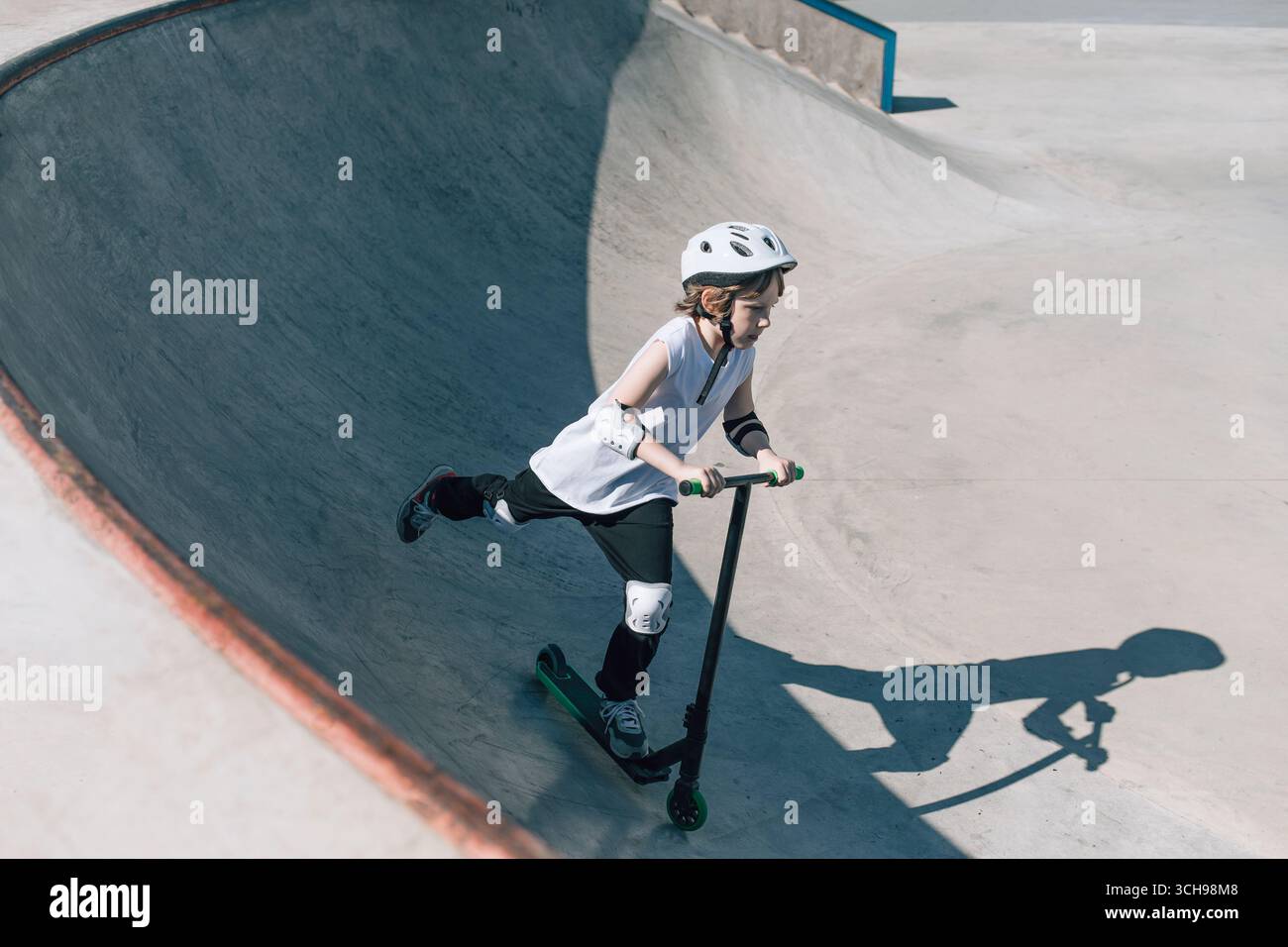 Scooter Rider è in grado di eseguire trucchi con abilità nello skatepark Foto Stock