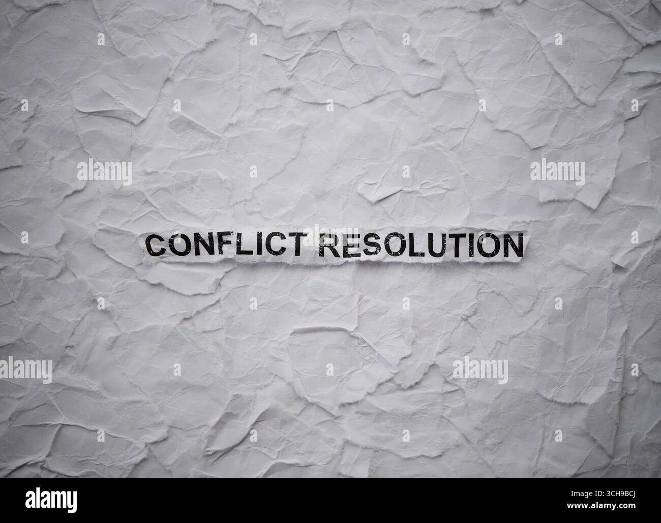 Pezzo di carta arricciato con Words Conflict Resolution su uno sfondo strappato di pezzi di carta bianca Foto Stock