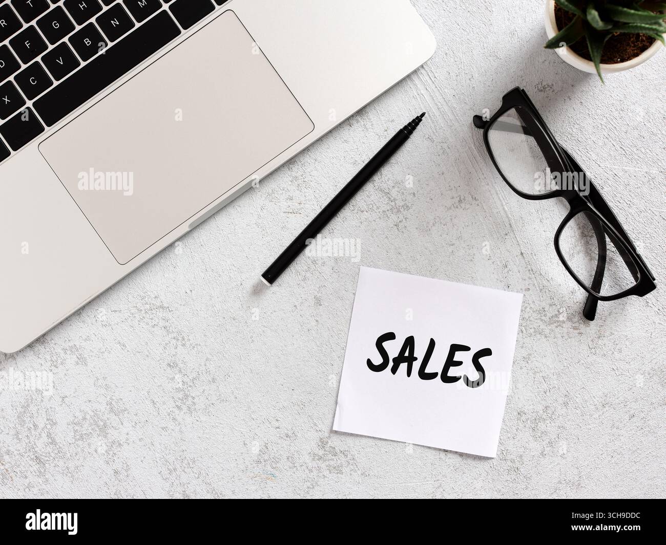 Scrivania da ufficio con laptop, penna, occhiali e appunti con scritture di vendita, per promuovere strategie di marketing e di business. Gestione delle vendite. Foto Stock