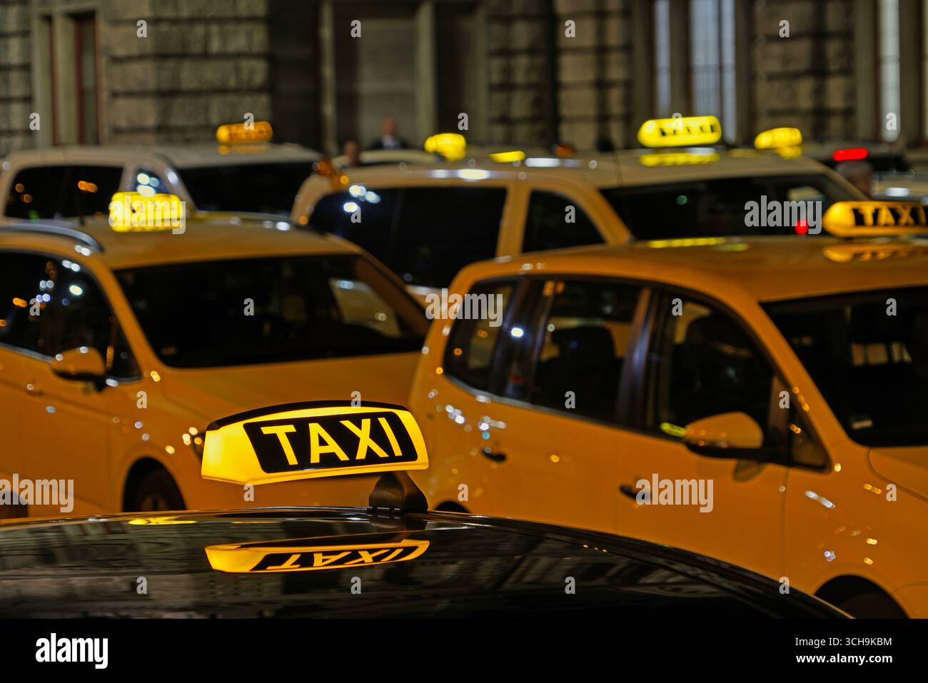 molti taxi attendono di notte alla stazione dei depositi per offrire il servizio di fronte alla stazione ferroviaria principale di norimberga, in germania Foto Stock