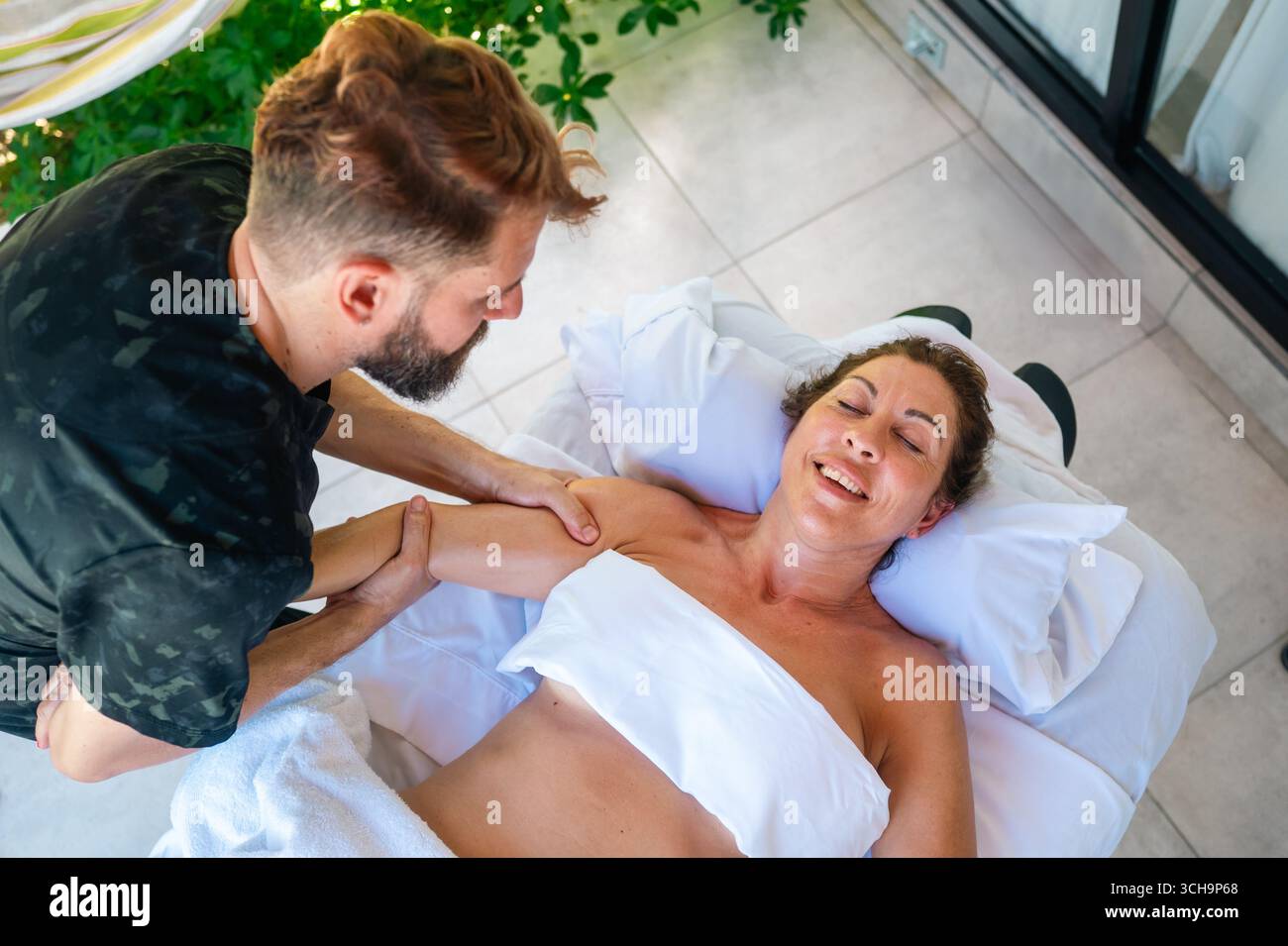 Distensione assistita del braccio durante il massaggio Foto Stock