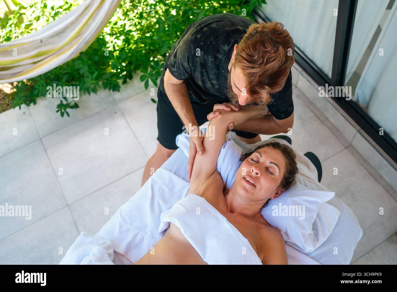 Distensione assistita del braccio durante il massaggio Foto Stock