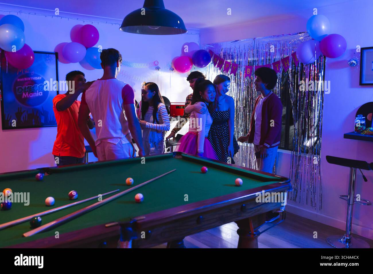 Diversi adolescenti festeggiano a casa, si divertono con palloncini e biliardo. festeggiamenti, adolescenti diversi, amici diversi, tempo libero, intrattenitori Foto Stock