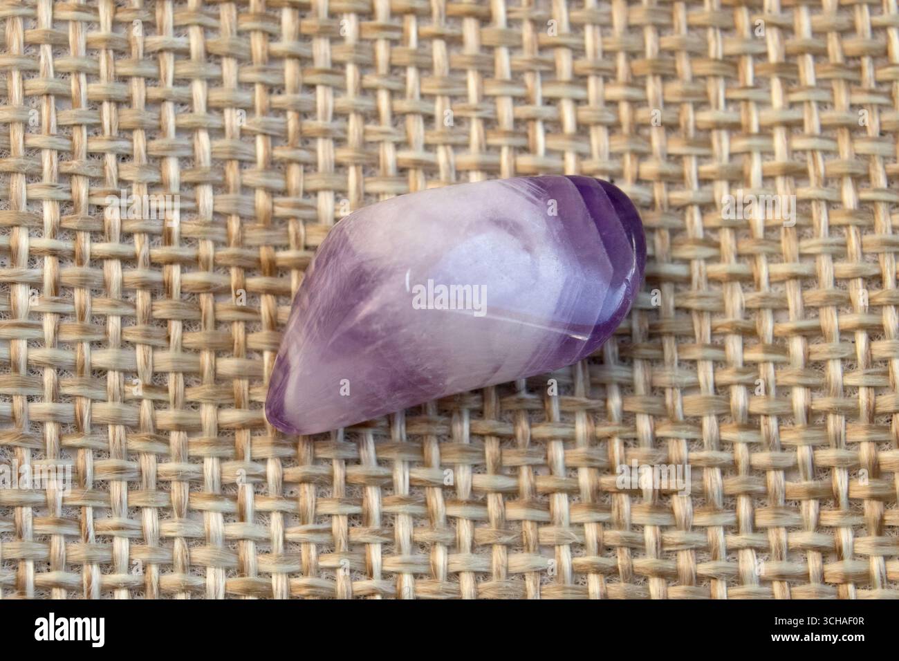 set di varie pietre minerali naturali ametista e pietre preziose su sfondo viola, vista dall'alto parzialmente messa a fuoco Foto Stock