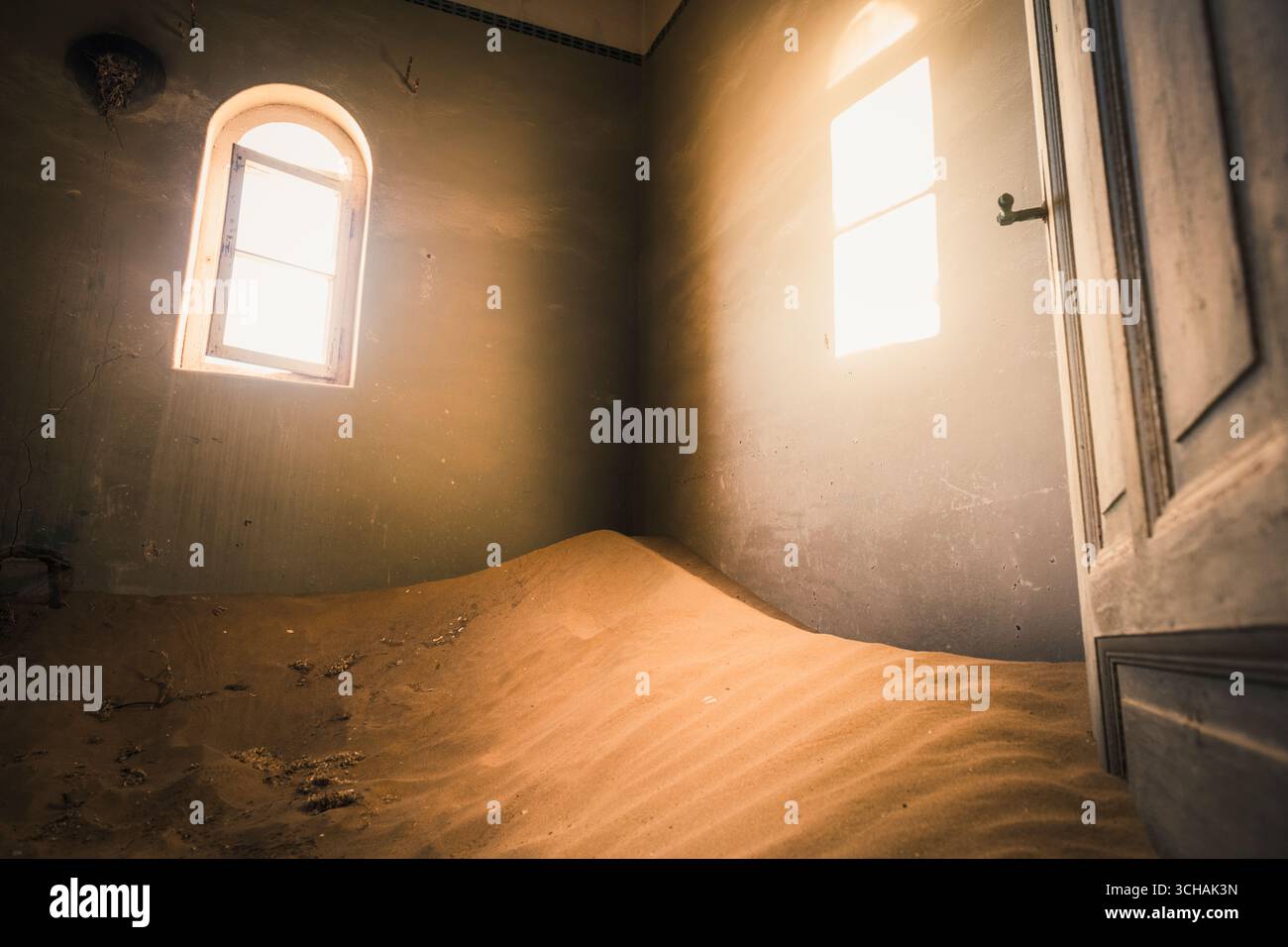 La luce del sole entra in una stanza piena di sabbia a Kolmanskop Foto Stock