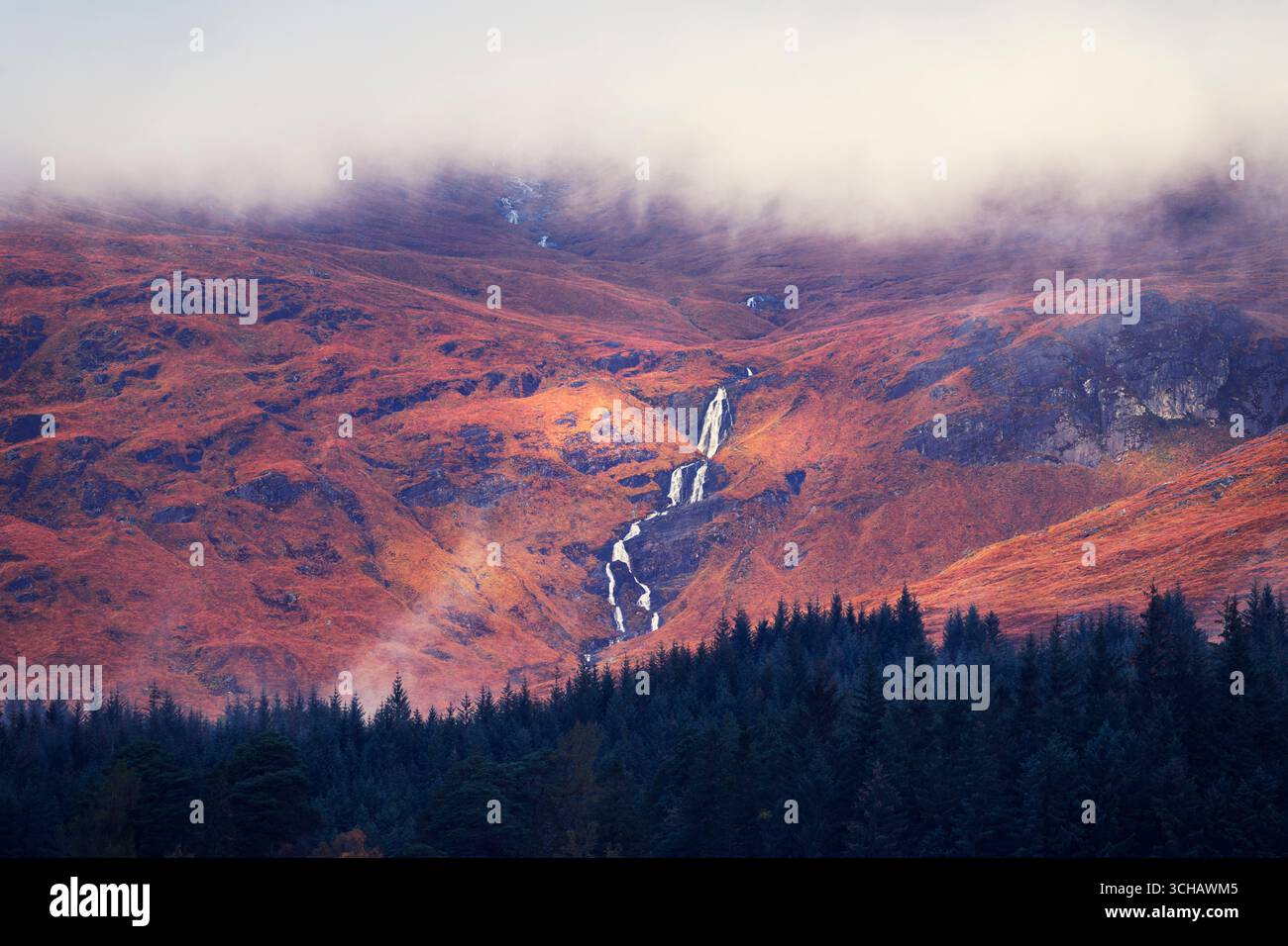 Cascate d'acqua da una foschia protetta Stob Ghabhar attraverso Allt Toaig, vista da Loch Tulla nelle Highlands scozzesi. Foto Stock