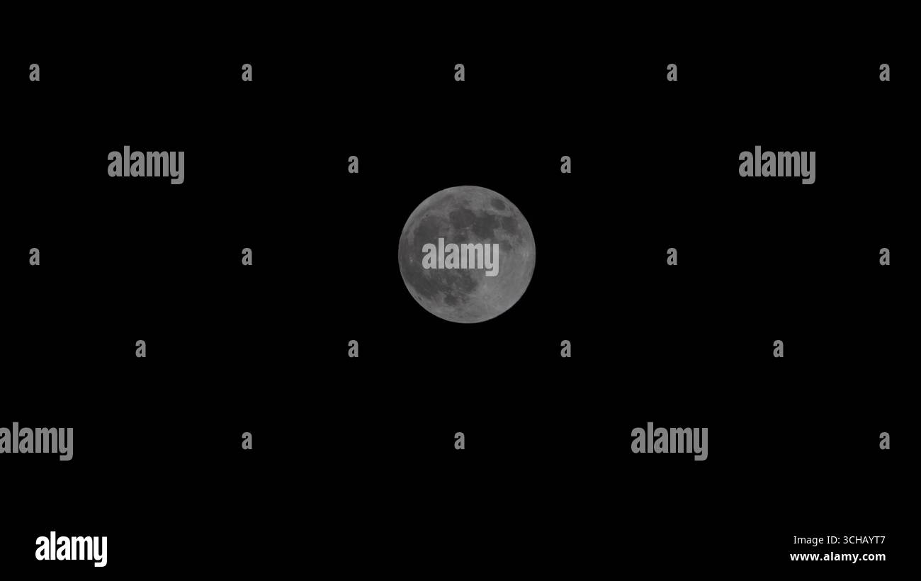 Luna piena fotografata contro un cielo notturno buio, con dettagli della superficie lunare. Foto Stock